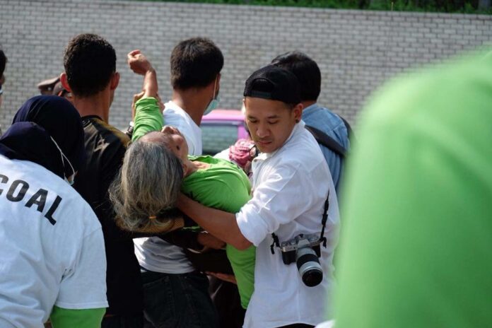 Anti-coal campaigners take a hunger striker away from the protest in front of the U.N. office in Bangkok