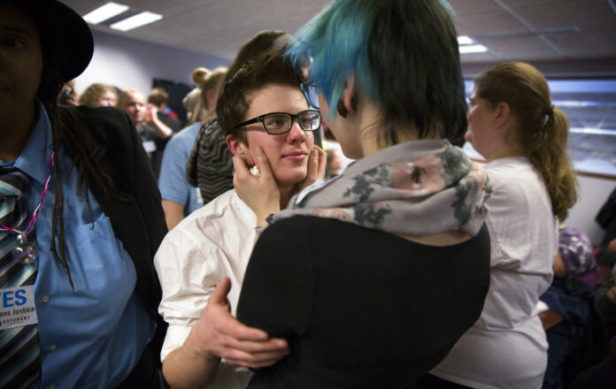 FILE - In this Dec. 4, 2014 file photo, Elliott Kunerth, 17, a transgender male high school student in Mankato, hugs his girlfriend, Kelsi Pettit, 17, after the Minnesota State High School League board voted to pass the Model Gender Identity Participation in MSHSL Activities Policy in Brooklyn Park, Minn. Photo: Leila Navidi / Star Tribune via AP