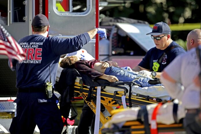 Medical personnel tend to a victim following a shooting Wednesday at Marjory Stoneman Douglas High School in Parkland, Florida. John McCall / Associated Press