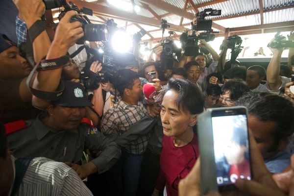 Aung San Suu Kyi is surrounded by the media as she arrives at a polling station in Yangon, Myanmar. Photo: Mark Baker / Associated Press