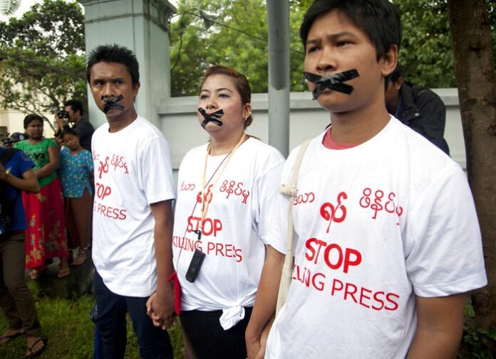 Myanmar journalist Wa Lone, right, stands with other journalists with their mouths taped to symbolize the government's crackdown on media in Yangon, Myanmar. Khin Maung Win / Associated Press