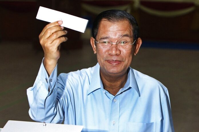 Cambodian Prime Minister Hun Sen of ruling Cambodian People's Party shows off a ballot paper before voting for senate election Sunday at Takhmau polling station in Kandal province, southeast of Phnom Penh, Cambodia. Photo: Heng Sinith / Associated Press