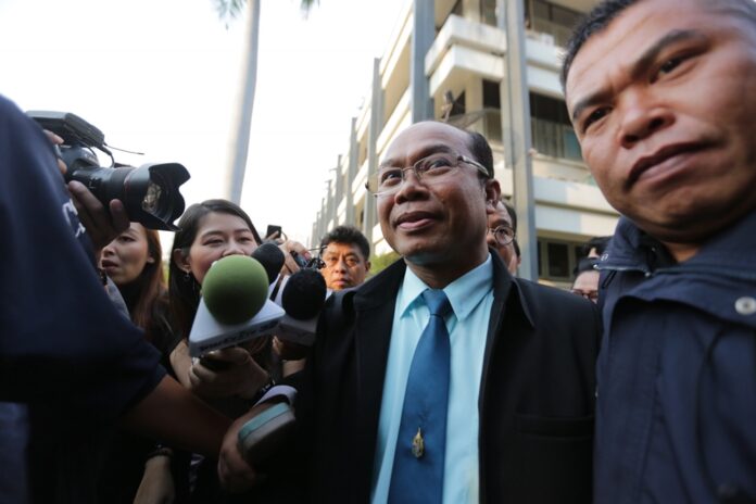 Police escort Preecha Kraikruan on Wednesday to Crime Suppression Division in Bangkok