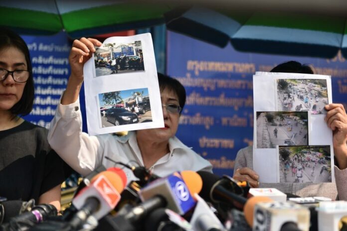 Boonsri Saengyoktrakarn and Rattanachat Saengyoktrakarn hold up photos of people parking illegally in front of their house.