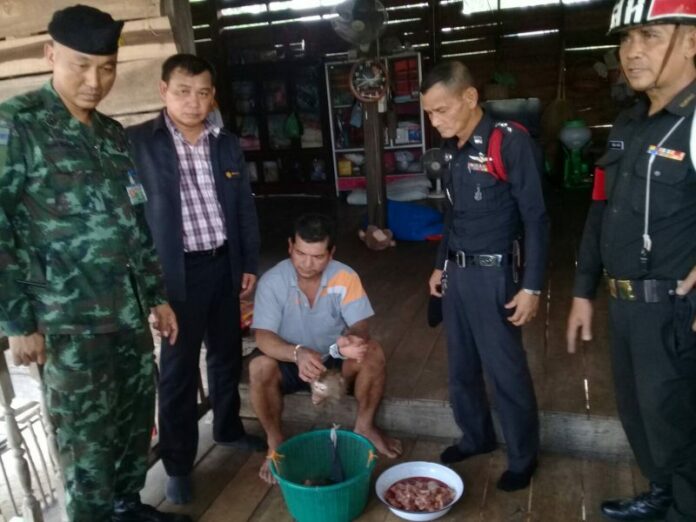 Police and wildlife officials with Nikorn Manpakdee and various macaque remains on Friday in Tak province.