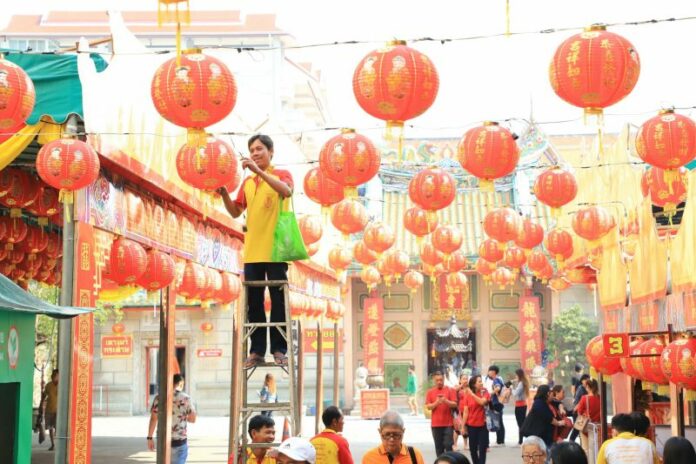 A man hangs Chinese lanterns in February morning in Yaowarat.