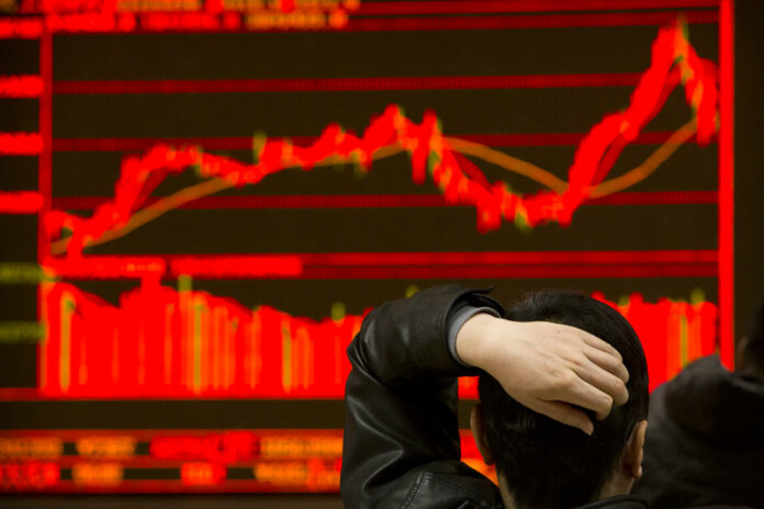 An investor monitors stock prices at a brokerage house in Beijing in February. Photo: Mark Schiefelbein / Associated Press