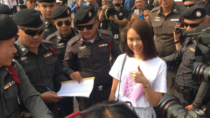 Pro-democracy activist Nuttaa Mahattana with police Thursday in Bangkok.