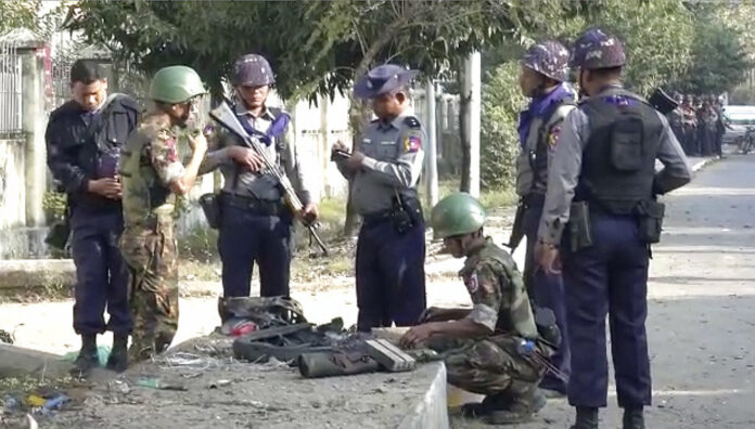 In this image made from video, police and officials inspect the site of a bomb explosion early Saturday in Sittwe, capital of Rakhine State. Photo: Associated Press