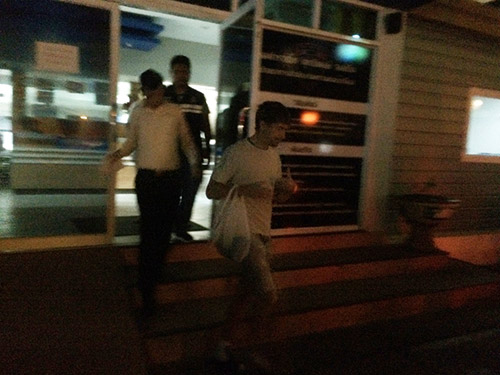 Alexander Kirillov is led out from Pattaya's immigration offices Tuesday night to be taken to a detention center. Photo: Teeranai Charuvastra