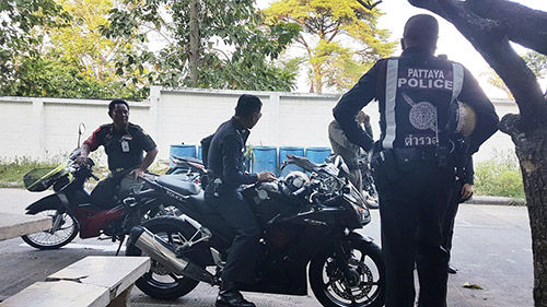 Some of the 20-plus immigration and regular police officers who showed up in unusual force to escort the Russians on Tuesday afternoon from the Pattaya Pronvicial Court. Photo: Todd Ruiz