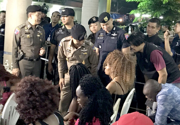 Police Maj. Gen. Surachet Hakpal talks to an arrested woman Thursday morning at Nana Hotel.