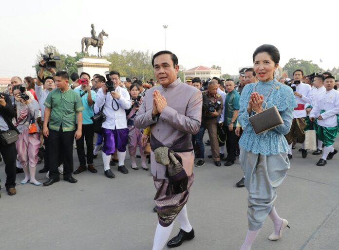 Prayuth Chan-ocha and his wife Naraporn Chan-ocha greet reporters Feb. 14 at a fair held in Bangkok’s Royal Plaza.