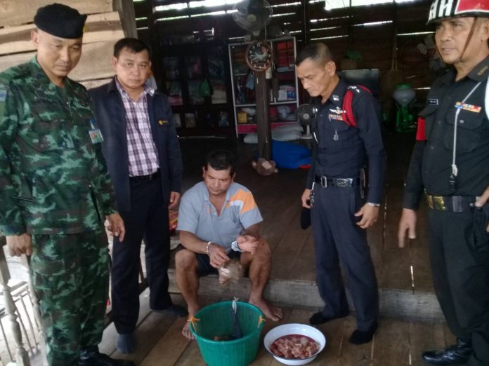 Police and wildlife officials with Nikorn Manpakdee and various macaque remains on Friday in Tak province.