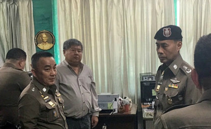Premchai Karnasuta, third from left, meets police at the Thong Paphum Police Station in Kanchanaburi province in response to a third summons order.