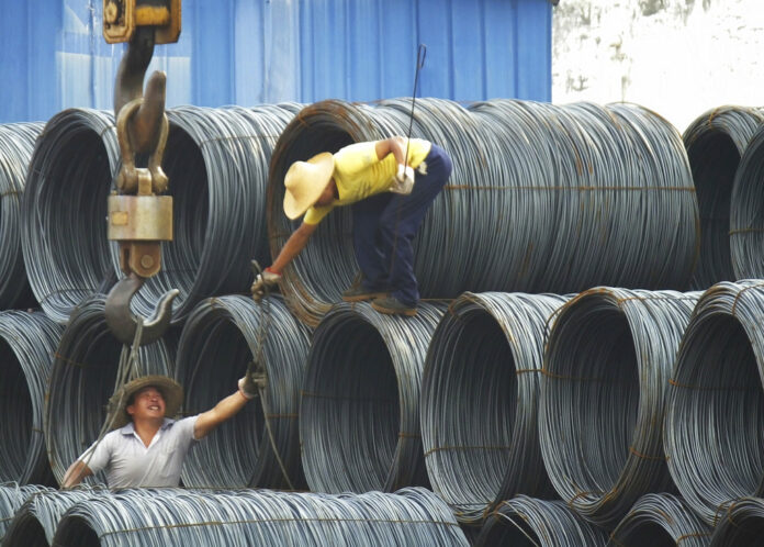 Laborers at work at steel market in Yichang, China. Photo: Chinatopix / Associated Press