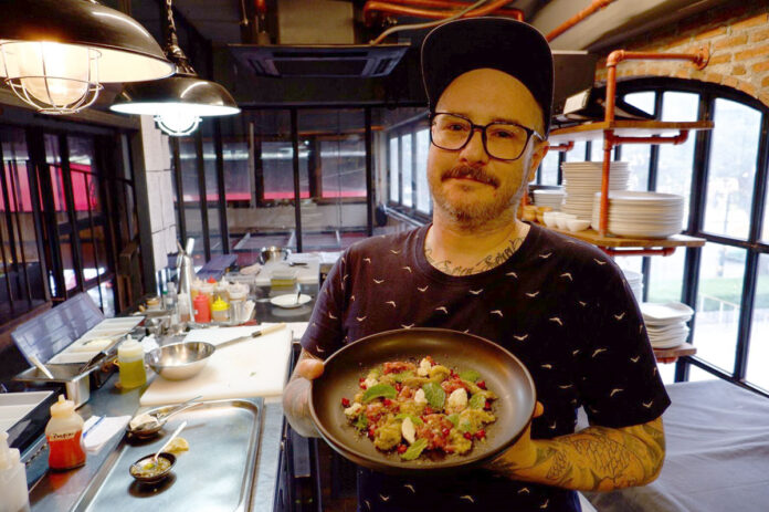 Jess Barnes holds a plate of goat tartare at Viva Thonglor.