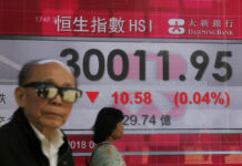 Asian Shares Mixed as Tech Losses Weigh in Muted Trading People walk past an electronic board showing Hong Kong share index outside a local bank in Hong Kong on Thursday. Photo: Kin Cheung / Associated Press
