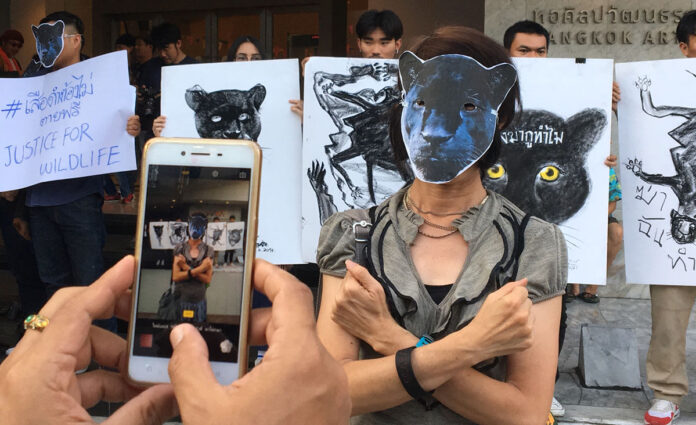 A protester performs a crossed-armed salute from the movie ‘Black Panther’ at a protest by the T’Challa group Sunday at the Bangkok Arts and Culture Center.