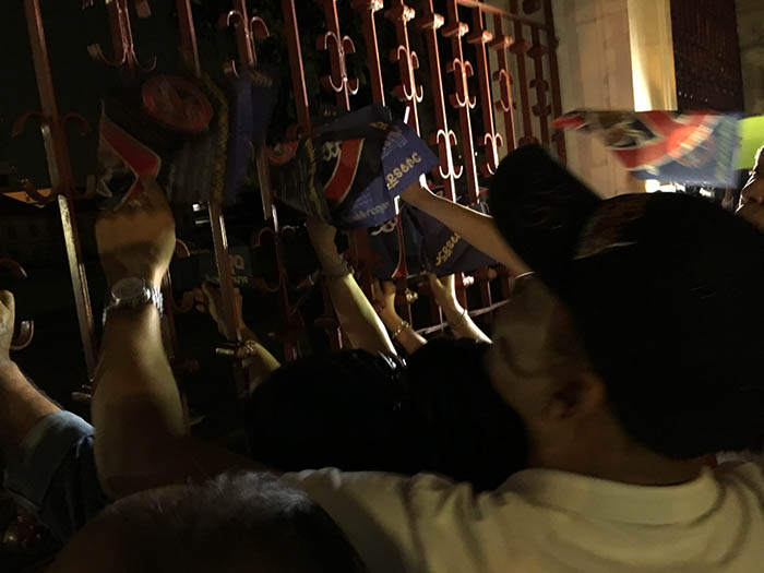 Protesters leave flyers in the fence outside army headquarters.