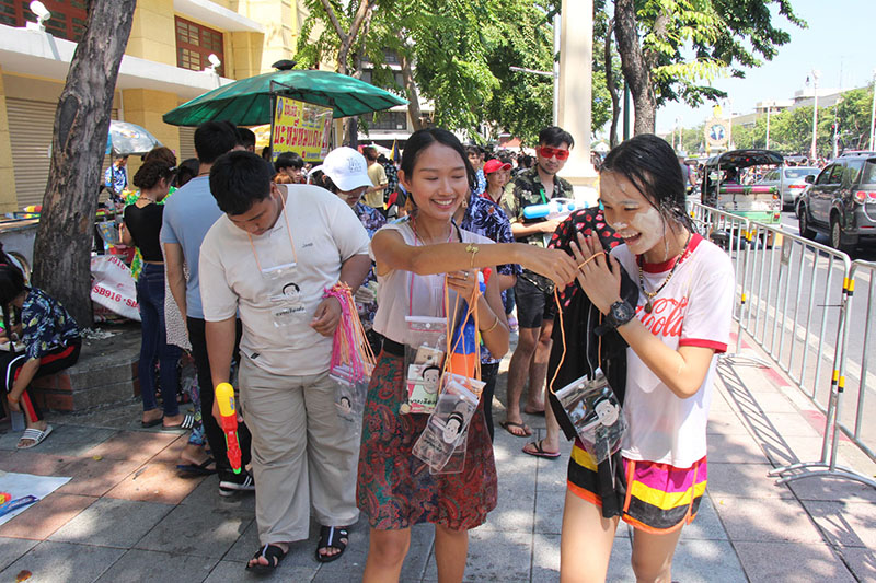 Pro-democracy activists hand out phone covers satirizing junta leader Prayuth Chan-ocha on Ratchadamnoen Avenue.