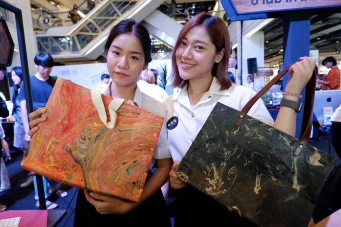 Chanapon Sanpradit and Ploysuree Tangtrakarn, both 22, present their Tourism Communications final thesis Friday at Siam Center for Srinakharinwirot University where they developed bags out of mulberry paper for a Chiang Mai tourist destination.