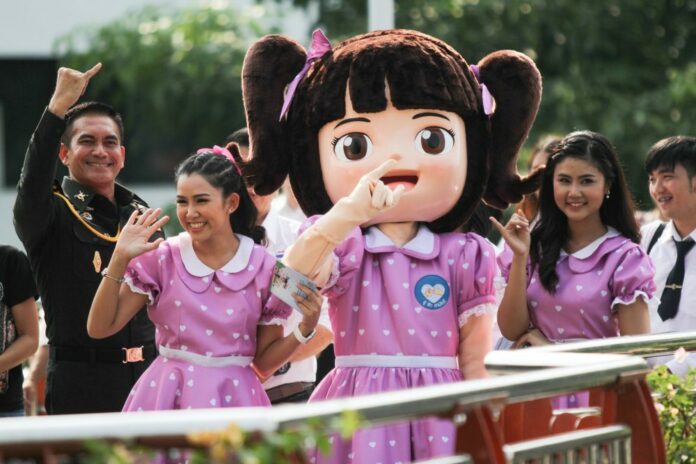 Military spokesman Wanchana Sawasdee, at left, and a mascot promoting national reconciliation campaign April 6 at Victory Monument in Bangkok.