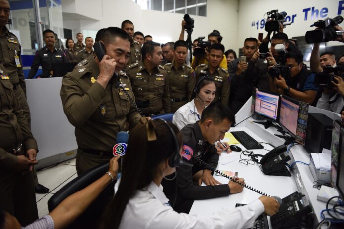 Gen. Chakthip Chaijindra receives a call during a Wednesday visit to the 191 emergency center. Photo: Matichon