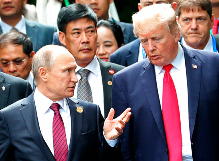 President Donald Trump, right, and Russia President Vladimir Putin talk during the family photo session in 2017 at the APEC Summit in Danang. Photo: Mikhail Klimentyev / Associated Press