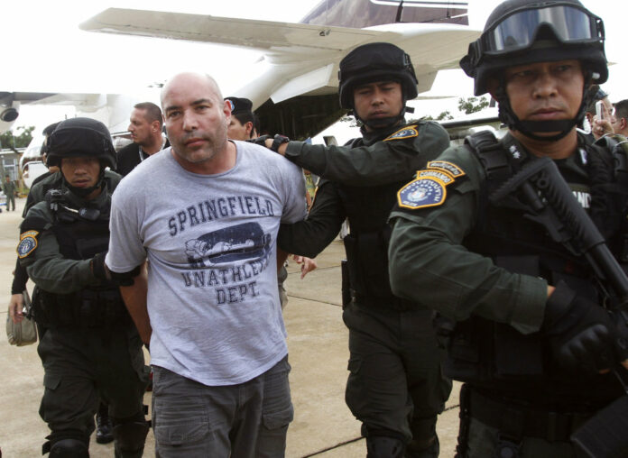 Joseph Hunter, second from left, a former U.S. Army sniper who became a private mercenary, is in the custody of Thai police commandos after being arrested in 2013 in Bangkok. Photo: Sakchai Lalit / Associated Press