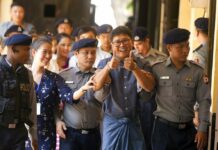 80 US Lawmakers Seek Release of Jailed Myanmar Reporters Reuters journalist Wa Lone, center, walks along with his wife Pan Ei Mon, second left, as he is escorted by police upon arrival at his trial Wednesday, April.11, 2018, Yangon, Myanmar. (AP Photo/Thein Zaw)
