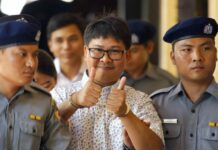 Myanmar Policeman Testifies to Entrapment Orders Reuters journalist Wa Lone, center, thumbs up as he is escorted by police upon arrival at the court for trial in Yangon. Photo: Thein Zaw / Associated Press
