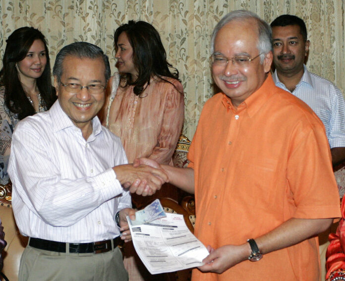 Malaysian Prime Minister Najib Razak, right, receives the party form from former Prime Minister Mahathir Mohamad, left, as Mahathir rejoin United Malays National Organization's (UMNO) in 2009 in Putrajaya, Malaysia. Photo: Lai Seng Sin / Associated Press Malaysian Prime Minister Najib Razak, right, receives the party form from former Prime Minister Mahathir Mohamad, left, as Mahathir rejoin United Malays National Organization's (UMNO) in 2009 in Putrajaya, Malaysia. Photo: Lai Seng Sin / Associated Press