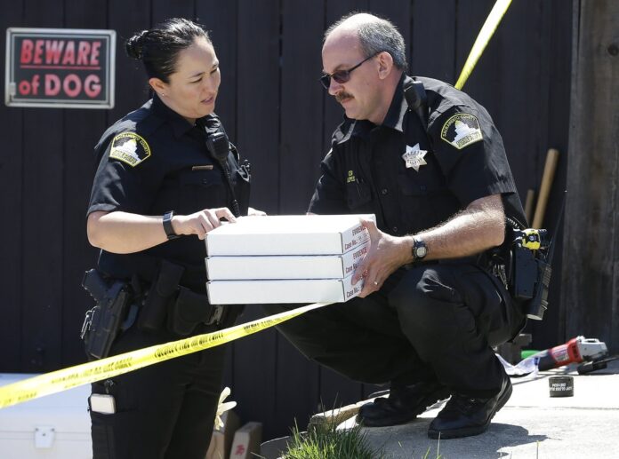 T. Abbott, left, and John Lopes, right, from the Sacramento County Sheriff's crime scene investigation office, conference about boxes of evidence gathered from the home of murder suspect Joseph DeAngelo, Thursday, April 26, 2018, in Citrus Heights, California. Photo: Rich Pedroncelli / Associated Press