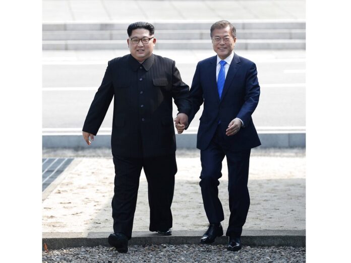 North Korean leader Kim Jong Un, left, and South Korean President Moon Jae-in cross the military demarcation line to the South side in April at the border village of Panmunjom in the Demilitarized Zone. Photo: Associated Press