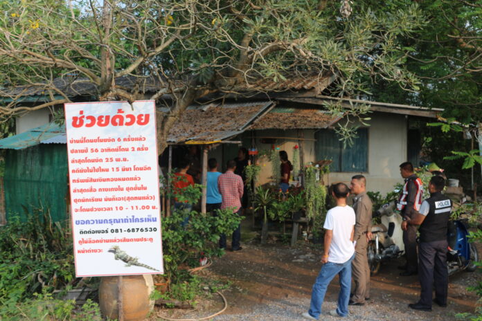 Police on Wednesday visit a house in Pathum Thani after a family hung a sign to protest being robbed six times. Photo: Matichon