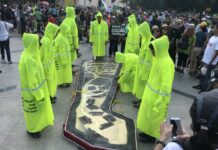 ‘Help Me Think’ Prayuth Says, Dodging on Doi Suthep Protest “pallbearers” prepare to carry a coffin Sunday in the shape of a section of Doi Suthep forest clear-cut for the construction of homes for judges and other court officers in Chiang Mai province.