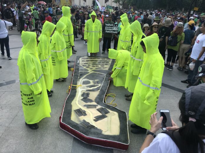 Protest “pallbearers” prepare to carry a coffin Sunday in the shape of a section of Doi Suthep forest clear-cut for the construction of homes for judges and other court officers in Chiang Mai province.