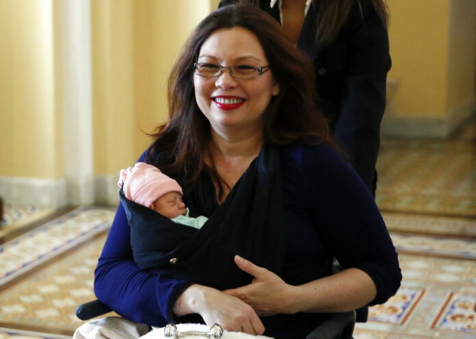 Sen. Tammy Duckworth, D-Illinois, carries her baby Maile Pearl Bowlsbey after they went to the Senate floor to vote Thursday on Capitol Hill in Washington. Photo: Alex Brandon / Associated Press