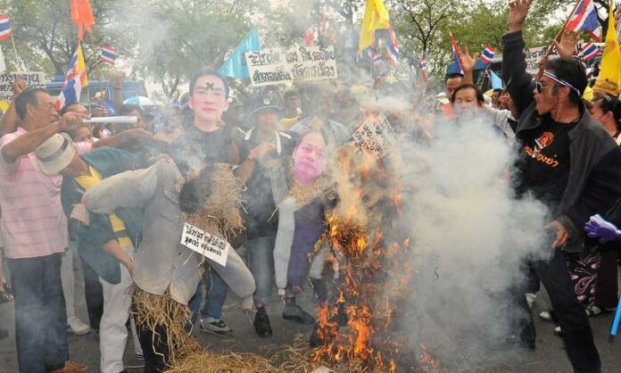 Royalist demonstrators burn effigies of law professor Worachet Pakeerut and other figures for advocating reform of the lese majeste in January 2012 at Thammasat University's Tha Prachan campus in Bangkok. Image: Thairath