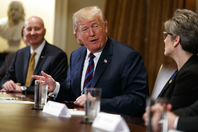 Gov. Pete Ricketts, R-Neb., left, listens as President Donald Trump speaks to Sen. Joni Ernst, R-Iowa, during a meeting with governors and lawmakers in the Cabinet Room of the White House, on Thursday. Photo: Evan Vucci / Associated Press