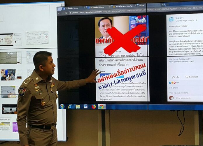 Maj. Gen. Surachet Hakpan shows the hoax article to reporters during a Wednesday news conference.