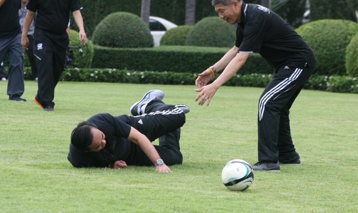 Junta chairman Prayuth Chan-ocha falls to the ground during a football match at Government House on Dec 14, 2016, just after he was tackled by his secretary Wilas Aroonsri.