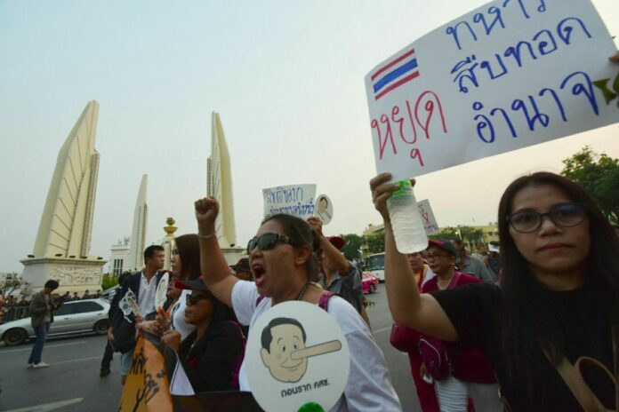 Pro-election demonstrators march on Ratchadamnoen Avenue on March 24
