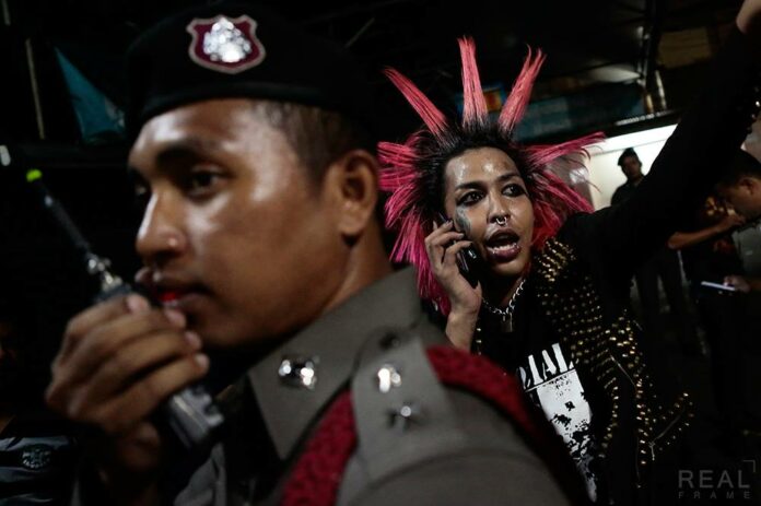 Kitikea ‘Guer Pure Punk’ Kanpim, an audience member who rushed the stage, is taken into custody at a punk music event Saturday at the October 14th Memorial in Bangkok. Photo: Patipat Janthong / Facebook