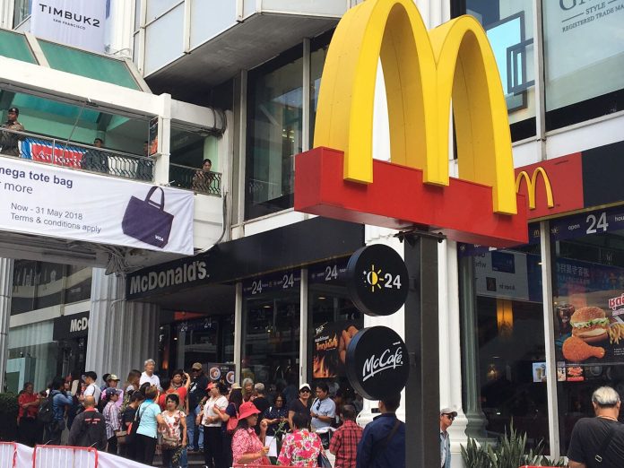 People gather in front of McDonald’s branch at Ratchaprasong Intersection on Saturday