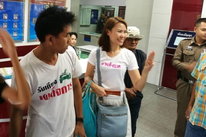 Nuttaa ‘Bow’ Mahattana flashes an anti-junta ‘three-finger salute’ at Phayathai Police Station on Thursday morning before she was taken to court.