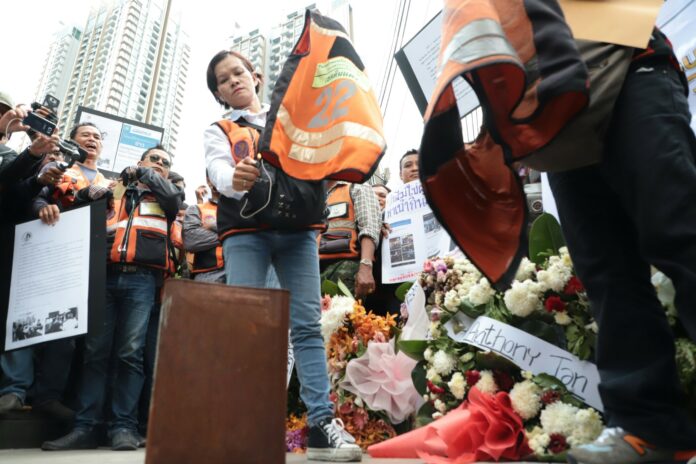 A win motosai burns her vest in protest on May 17 outside of Grab’s Bangkok offices. A win motosai burns her vest in protest on May 17 outside of Grab’s Bangkok offices.