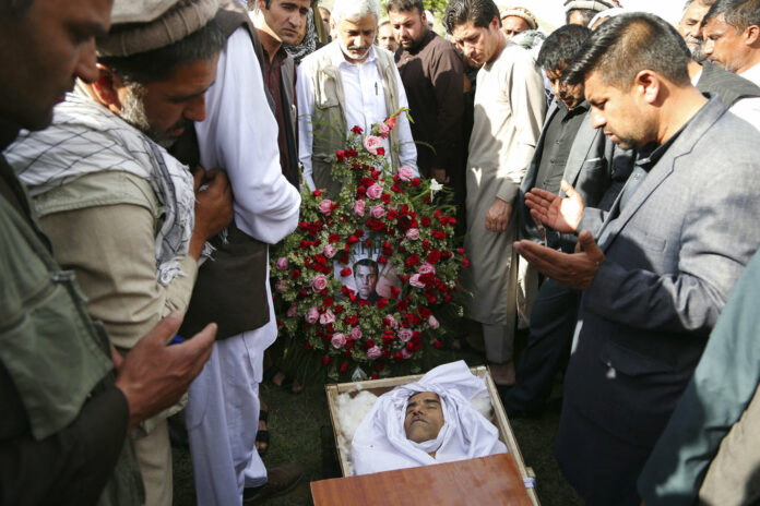 Relatives, colleagues and friends pray next to the body of AFP chief photographer, Shah Marai, who was killed in Monday in a second suicide attack in Guldara, a district of Kabul province, Afghanistan. Photo: Rahmat Gul / Associated Press