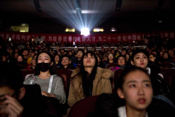 In this Thursday, March 22, 2018 photo, audience members watch a screening of the state-backed documentary